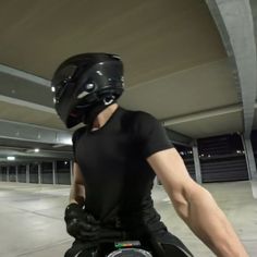 a man riding on the back of a motorcycle wearing a black helmet and holding onto his arm