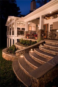 an outdoor patio with steps lit up at night