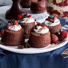 chocolate desserts with whipped cream and strawberries on a plate next to other desserts