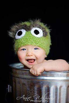 a baby wearing a green hat with big eyes