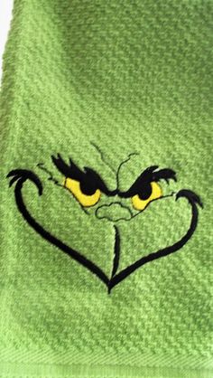 a green towel with an angry face drawn on it's side and yellow eyes