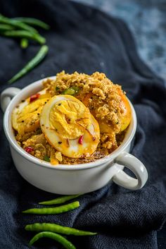 a white bowl filled with food on top of a blue cloth