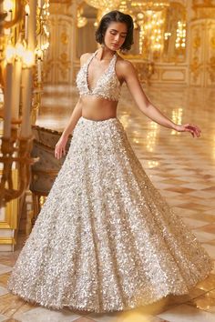 White net lehenga with an attached cancan and tonal bold sequins embroidery. Comes with a padded blouse and a dupatta.
Components: 3
Pattern: Embroidered
Type Of Work: Sequins
Neckline: Halter
Sleeve Type: Sleeveless
Fabric: Net
Color: White
Other Details: 
Approx Product Weight: 45-46 inches
Closure:
Lehenga: Side zip
Blouse: Back tie-ups
Occasion: Destination Wedding,Bride - Aza Fashions Sequin Lehenga, Seema Gujral, Gold Lehenga, White Lehenga, Full Sleeve Blouse, Floral Lehenga, Halter Blouse, Lehenga Designs Simple, Net Blouses