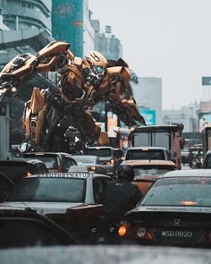 a giant robot that is standing in the middle of traffic on a street with cars