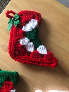 two crocheted christmas stockings sitting on top of a wooden table