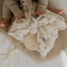 a baby laying on top of a white blanket