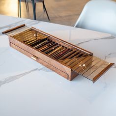 an open wooden box sitting on top of a white table