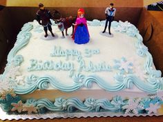 a frozen princess birthday cake in a box with figurines on top and frosting