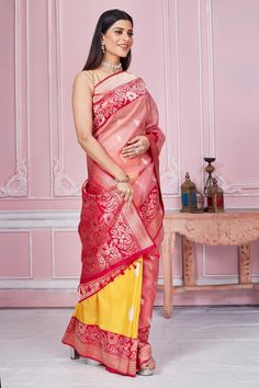 Radiate elegance on special occasions in this pink and yellow Banarasi saree with zari minakari border and heavy zari pallu. It comes with a blouse piece. Disclaimer: The shown stitched blouse on the model is for display purpose only. The saree comes with a matching blouse piece and finished with fall and piko. Yellow Banarasi Saree, Banarasi Sari, Tussar Silk Sarees, Fashion Journals, Tussar Silk Saree, Banarasi Saree, Traditional Fabric, Banarasi Sarees, Pink And Yellow