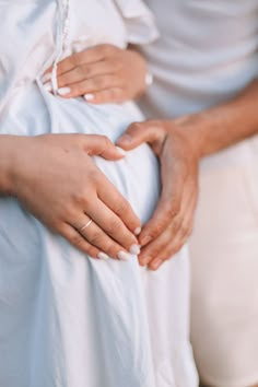 two people holding hands on their stomach