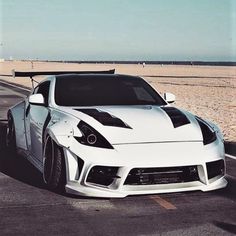 a white sports car parked on the beach