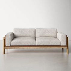 a white couch sitting on top of a wooden frame