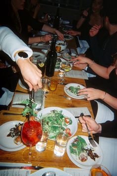 people sitting at a table with plates of food