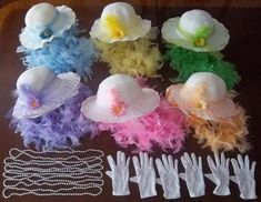 there are many hats with feathers on the table next to each other, including one flower