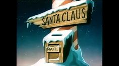 a wooden sign that says santa claus next to a mailbox in the snow covered ground