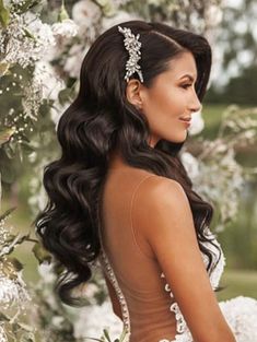 a woman in a wedding dress standing next to flowers