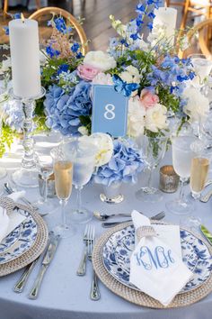 the table is set with blue and white flowers