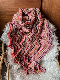 a multicolored blanket sitting on top of a chair