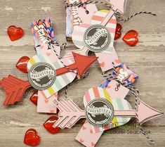 valentine's day tags with hearts and lollipops on a wooden table