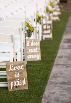 rows of white chairs lined up with wooden signs reading love is patient and it does not envy