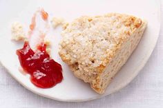 a white plate topped with two pieces of bread next to jelly on top of it