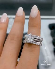 a woman's hand with a diamond ring on top of her finger and the engagement band