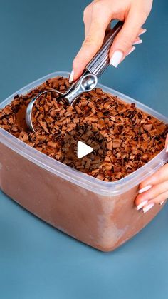 a person is scooping something out of a container with a pair of tongs