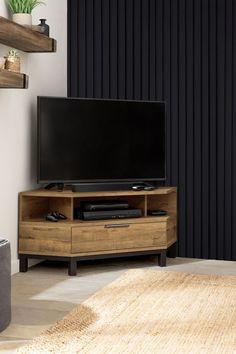 a flat screen tv sitting on top of a wooden entertainment center in a living room