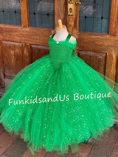 a green princess dress on display in front of a door with the words fun kids and boutique