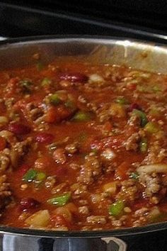 a pan filled with meat and vegetables cooking on the stove