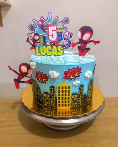 a spiderman themed birthday cake with the number five on it's top tier