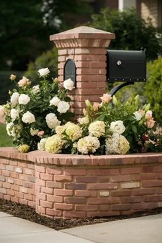 a brick mailbox with flowers in it