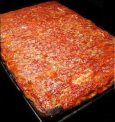 a deep dish pizza sitting on top of a black pan in the oven, ready to be cooked