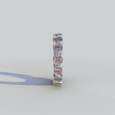 a ring with five different colored stones on it's sides, in front of a white background