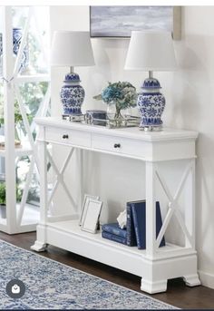 two blue and white vases sitting on top of a table next to a lamp