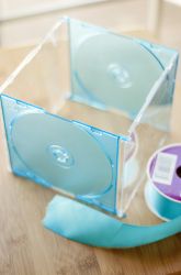 two cds in clear cases sitting on top of a table next to a tape dispenser