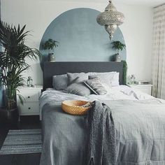 a bedroom with a large bed and potted plants on the wall next to it