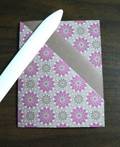 a white knife sitting on top of a piece of paper next to a napkin with flowers