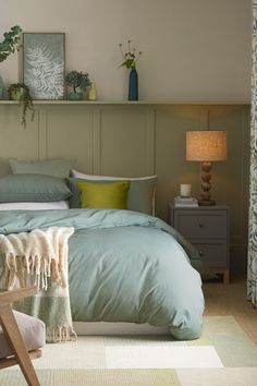 a bed with blue sheets and pillows in a bedroom