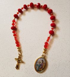 St. Joseph Single Decade Rosary with red beads and red and silver seed beads Please contact me with any questions  Tracking included with all US orders Handmade Red Beads For Christmas, Handmade Red Christmas Beads, Red Oval Beaded Bracelets For Gift, Festive Red Spiritual Beaded Bracelets, Red Spiritual Beaded Bracelets For Festive Occasions, Red Beaded Bracelets With Gold Round Beads, Handmade Red Rosary Bracelet With Round Beads, Red Spiritual Beads For Festive Occasions, Spiritual Red Beads For Festive Occasions