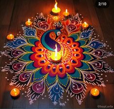 a decorated floor with lit candles and a peacock design on the ground in front of it