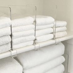 several rows of folded white towels on a shelf