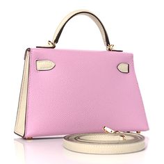 a pink handbag sitting on top of a white table next to a belt strap