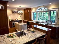 a large kitchen with marble counter tops and wooden cabinets, along with an island in the middle