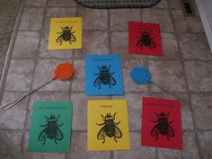 several different colored cards on the floor with magnets in front of them that have pictures of bugs