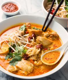 a white bowl filled with chicken and noodles