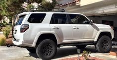 a white suv parked in front of a house