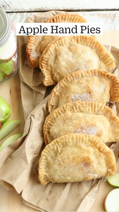 fried apple hand pies on parchment paper with apples in the background and text overlay that reads fried apple hand pies