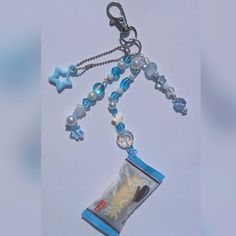 a small bag with beads and charms hanging from it's side on a chain