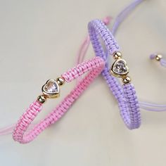 two bracelets with hearts on them sitting next to each other